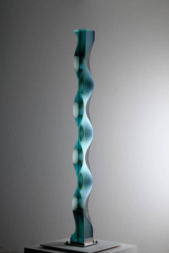 M.151201: large vertical glass sculpture by Japanese contemporary artist Toshio Iezumi, which combines convex and concave forms to create a motion-like effect.